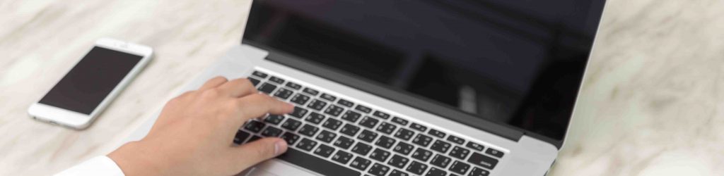 Closeup of business woman hand typing on laptop keyboard